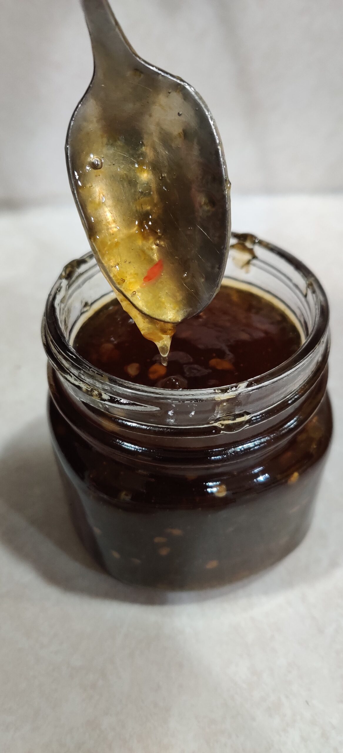 Apple Hot Pepper Jelly dripping off a spoon