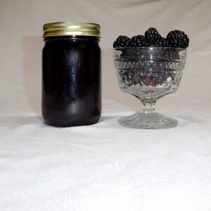 12 oz jar of Blackberry Jam surrounded by blackberries