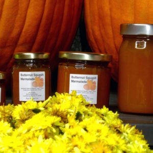All size jars of Butternut Squash Marmalade set in a closeup of fall background