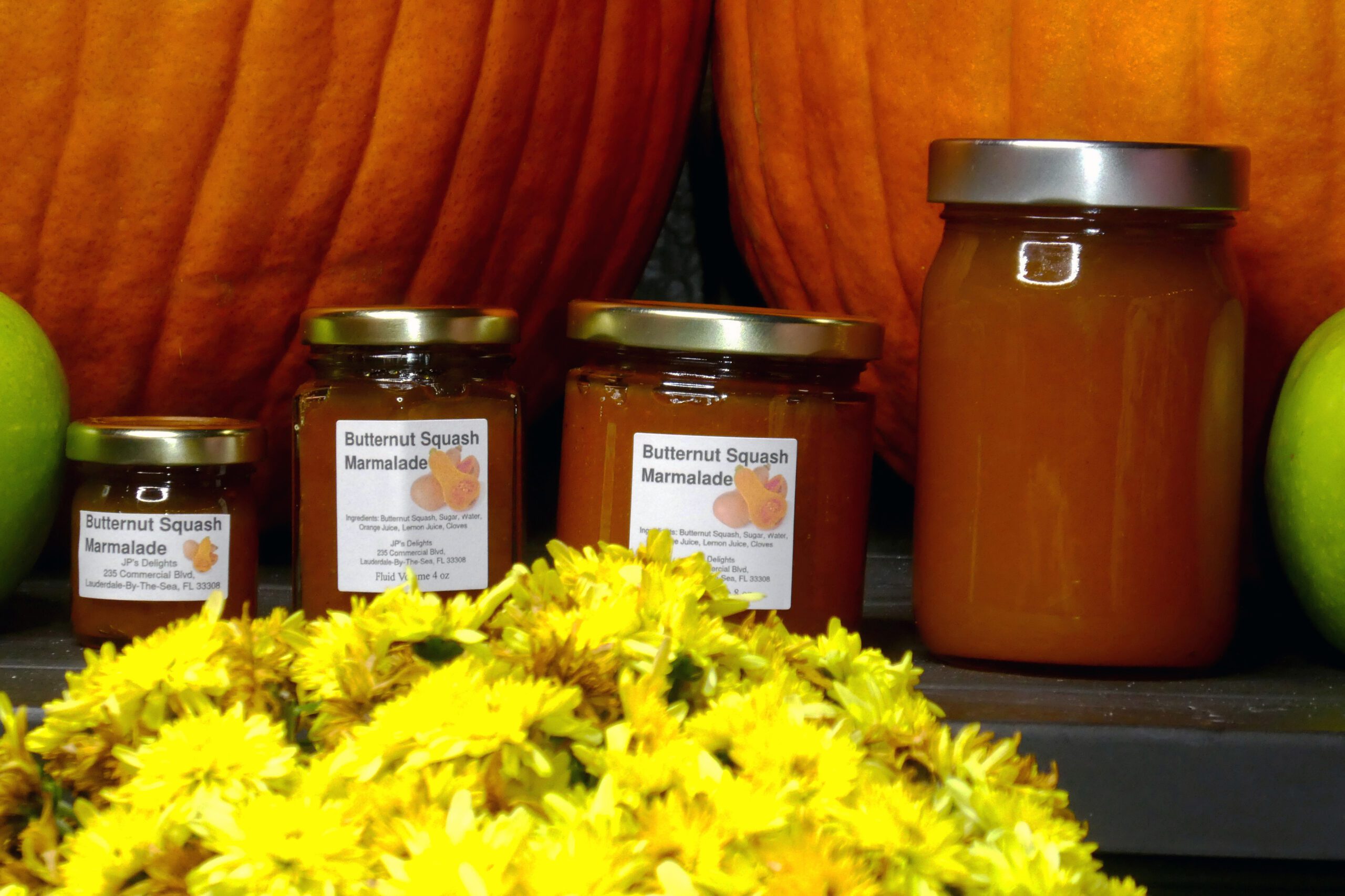 All size jars of Butternut Squash Marmalade set in a closeup of fall background