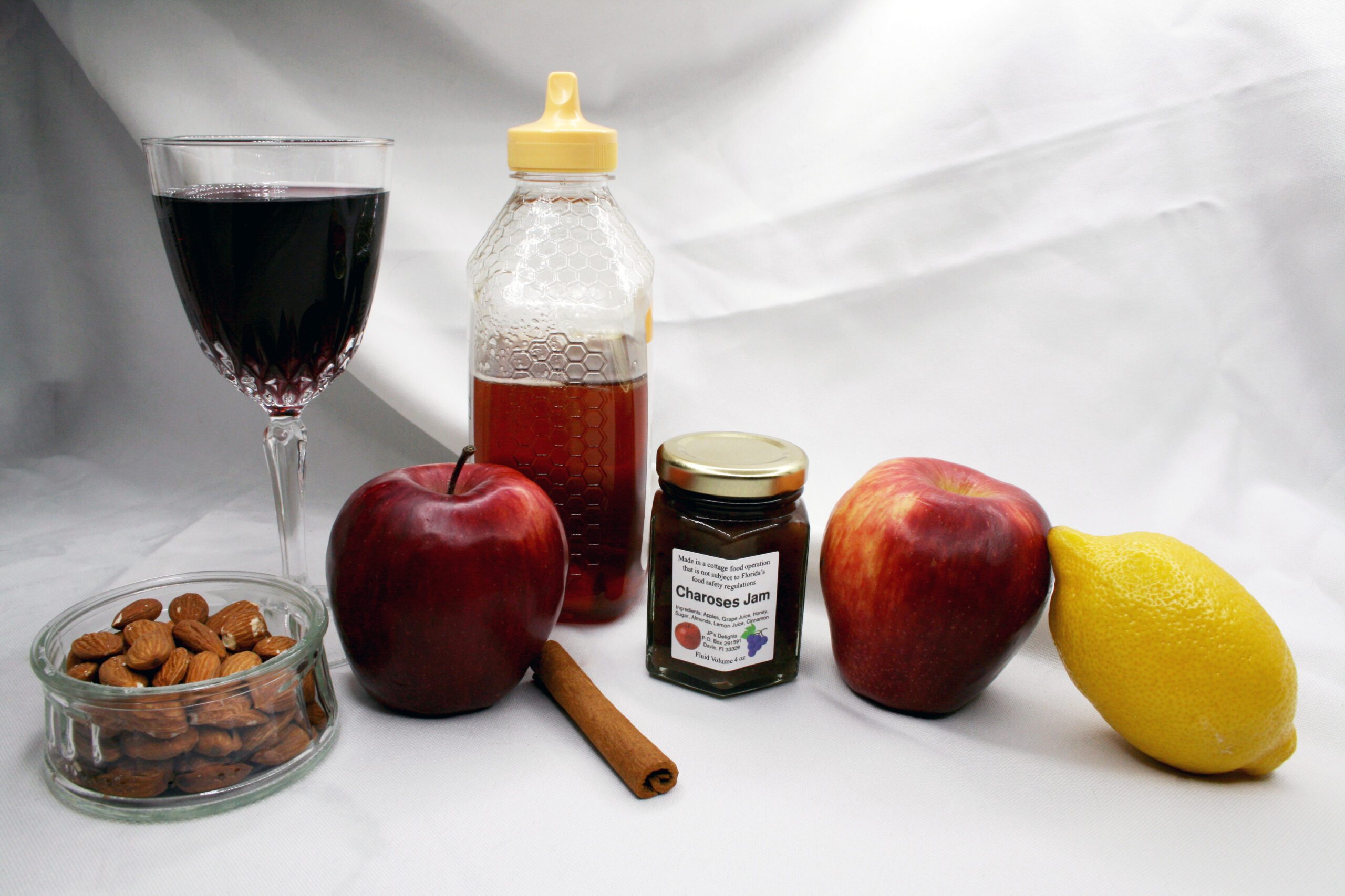 4 oz jar of Charoses Jam surrounded by its ingredients