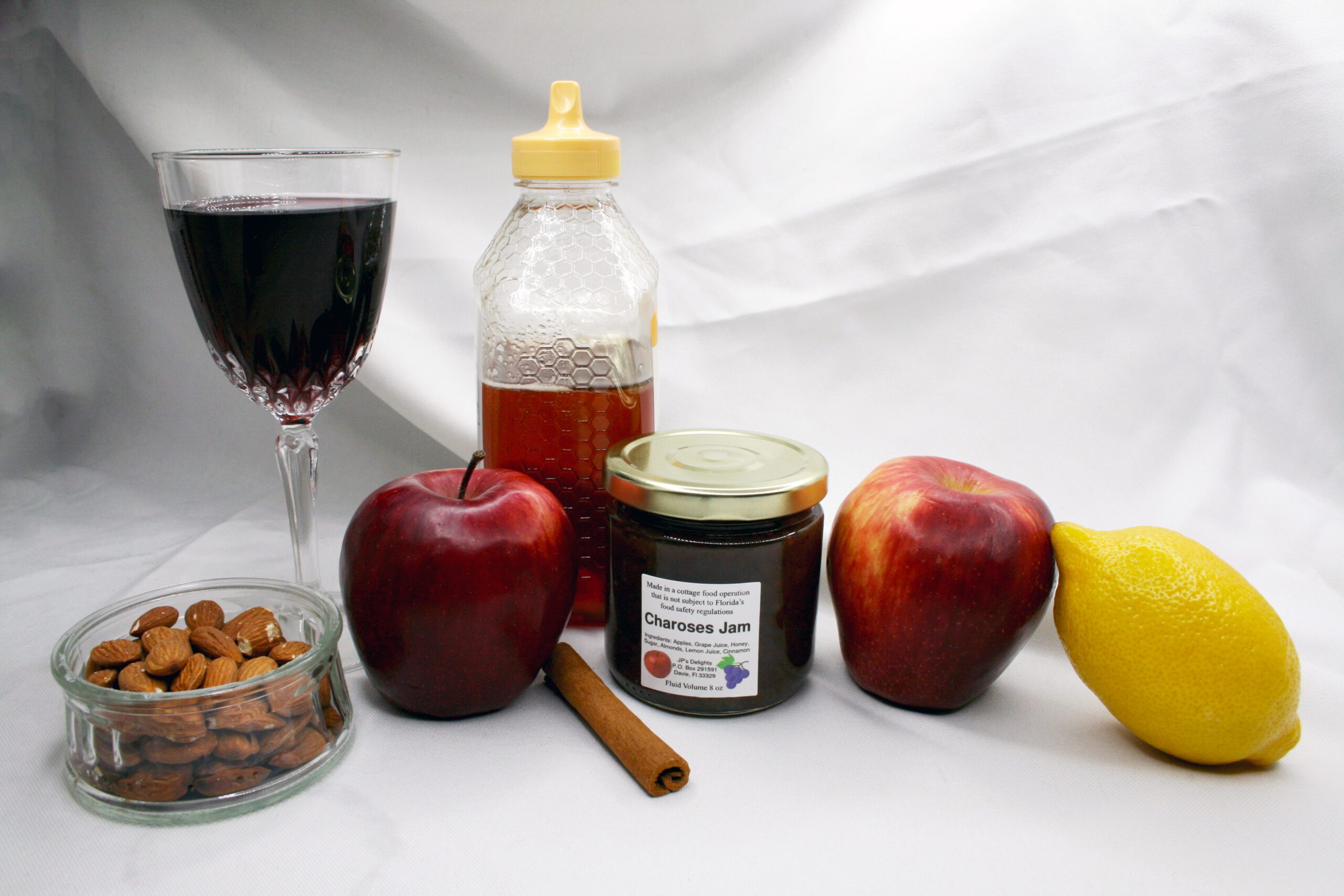 8 oz jar of Charoses Jam surrounded by its ingredients
