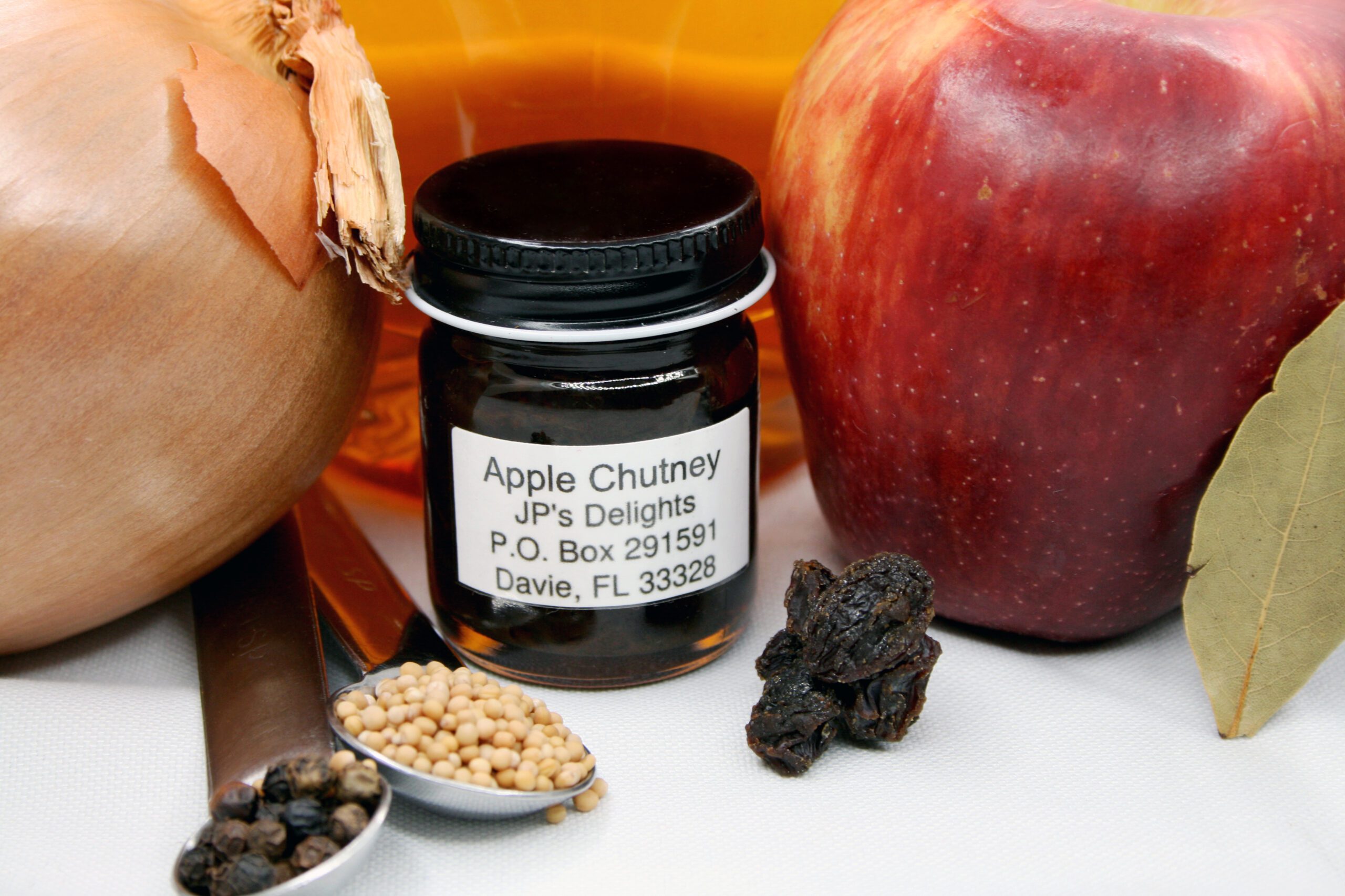 1.5 oz jar of Apple Chutney surrounded by its ingredients
