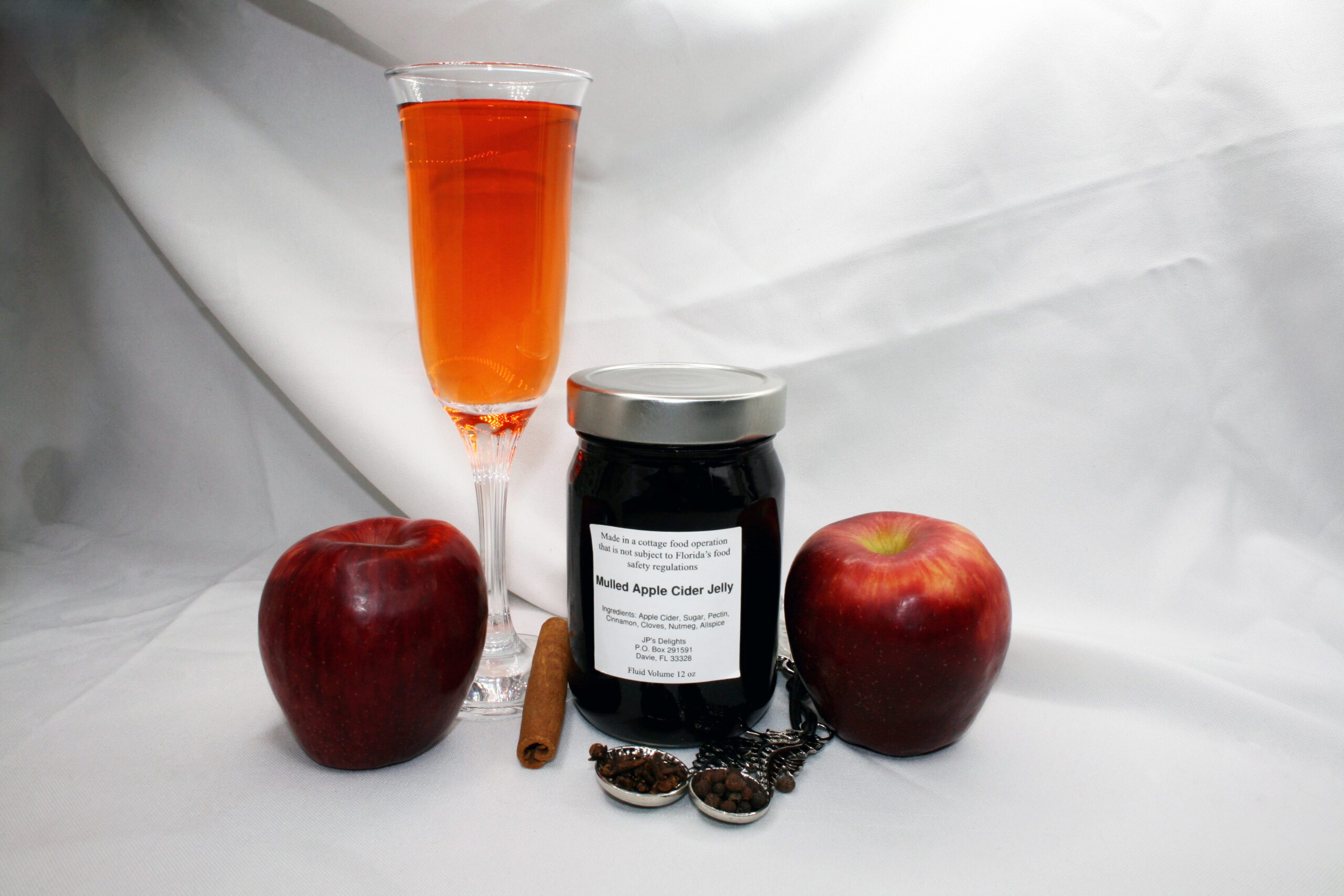 12 oz jar of Apple Cider Jelly surrounded by its ingredients