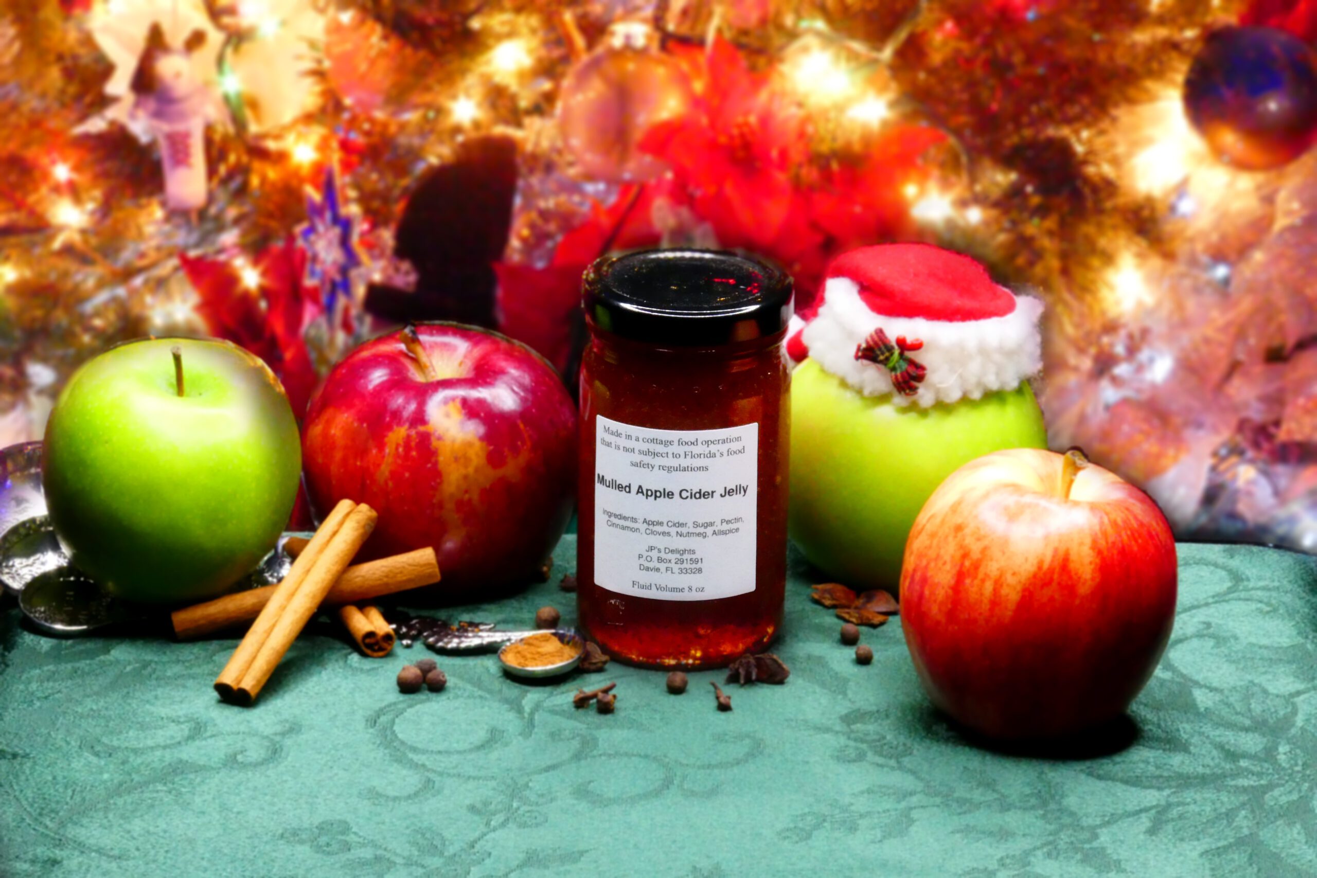 8 oz jar of Apple Cider Jelly surrounded by its ingredients with a Christmas background
