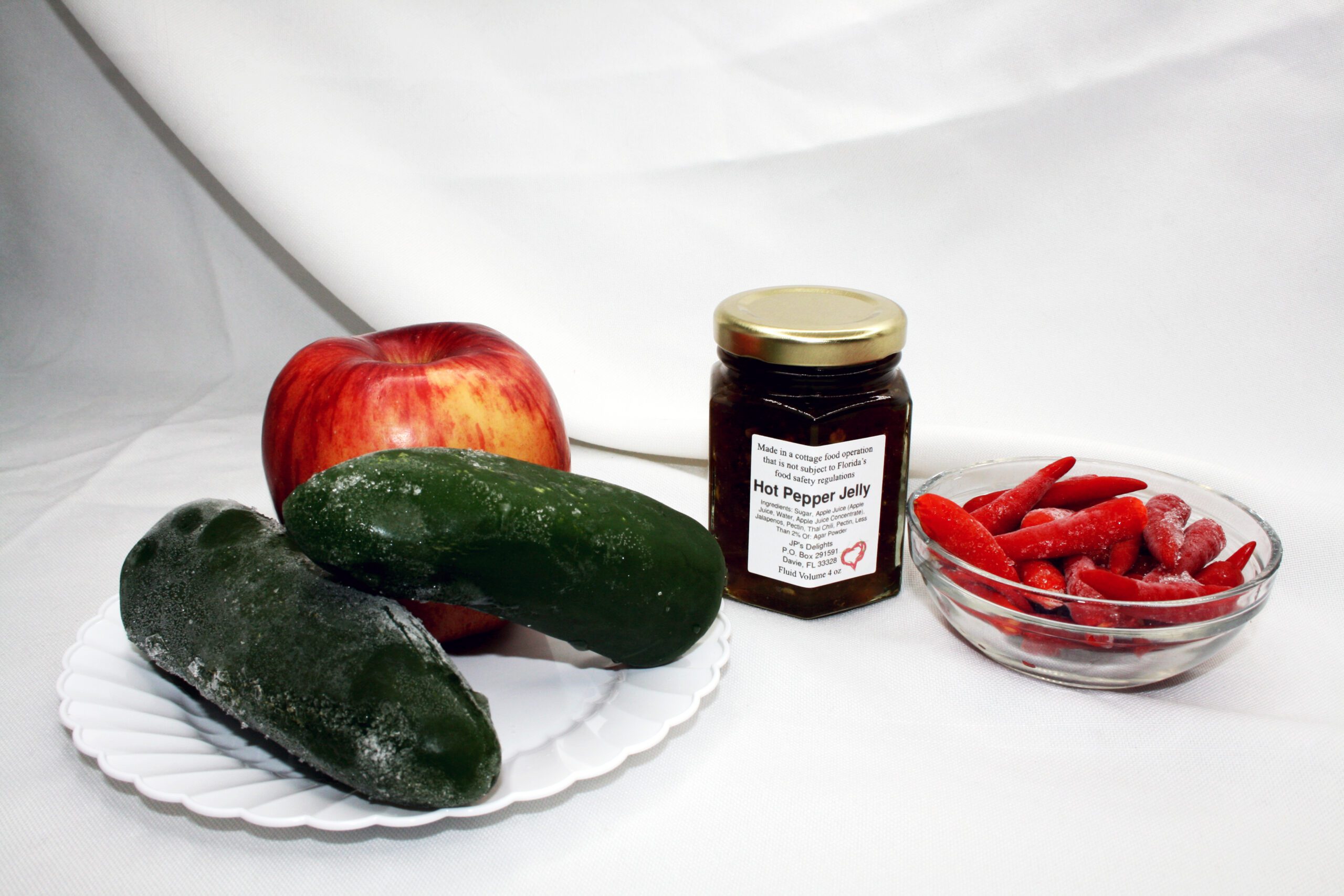 4 oz jar of Apple Hot Pepper Jelly surrounded by its ingredients