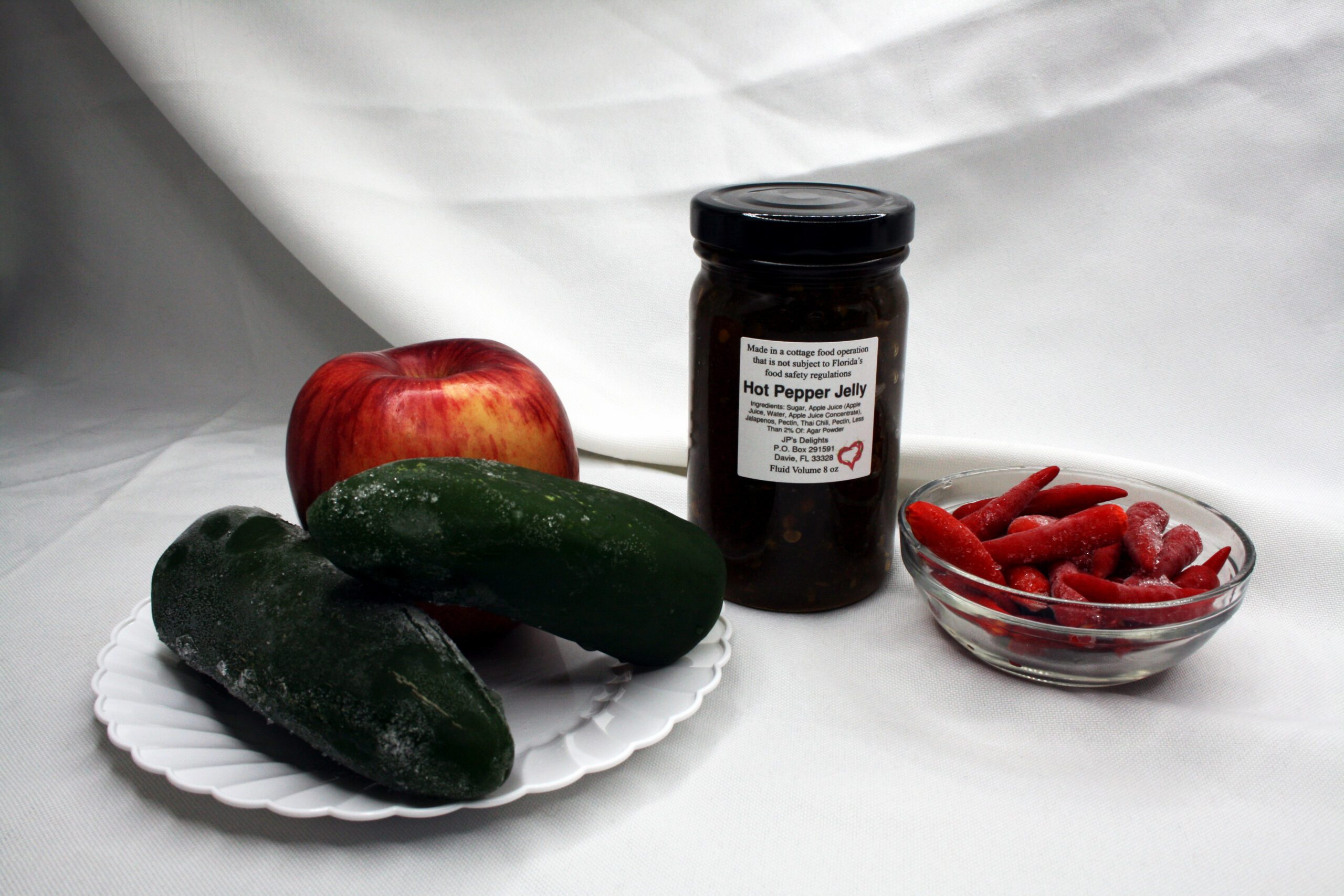 8 oz jar of Apple Hot Pepper Jelly surrounded by its ingredients