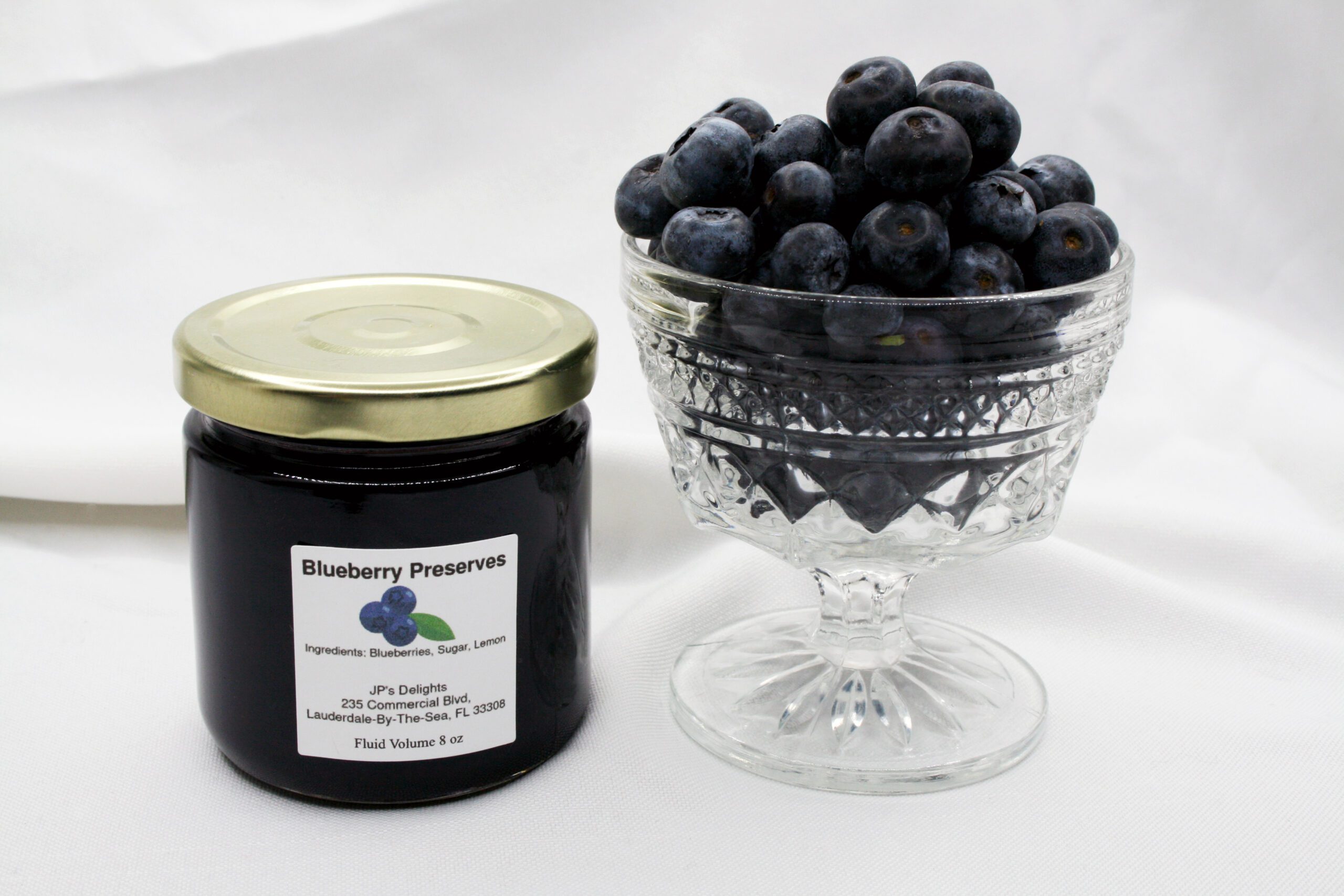 8 oz jar of Blueberry Preserves surrounded by blueberries