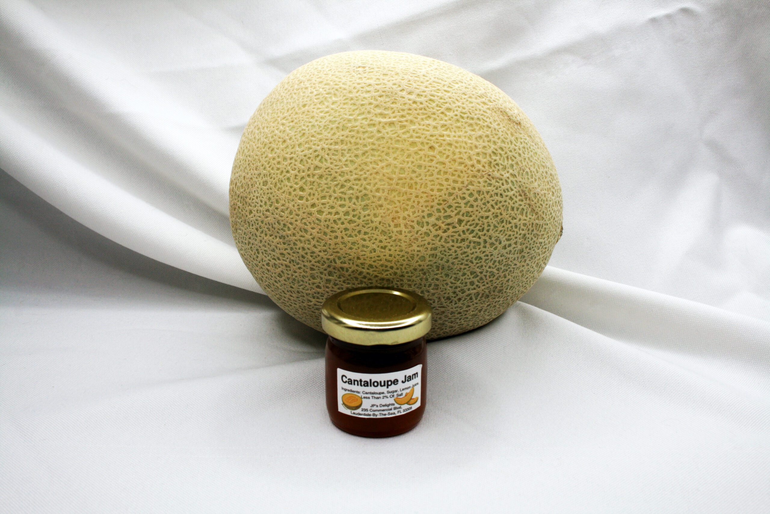 1.5 oz jar of Cantaloupe Jam surrounded by its ingredients