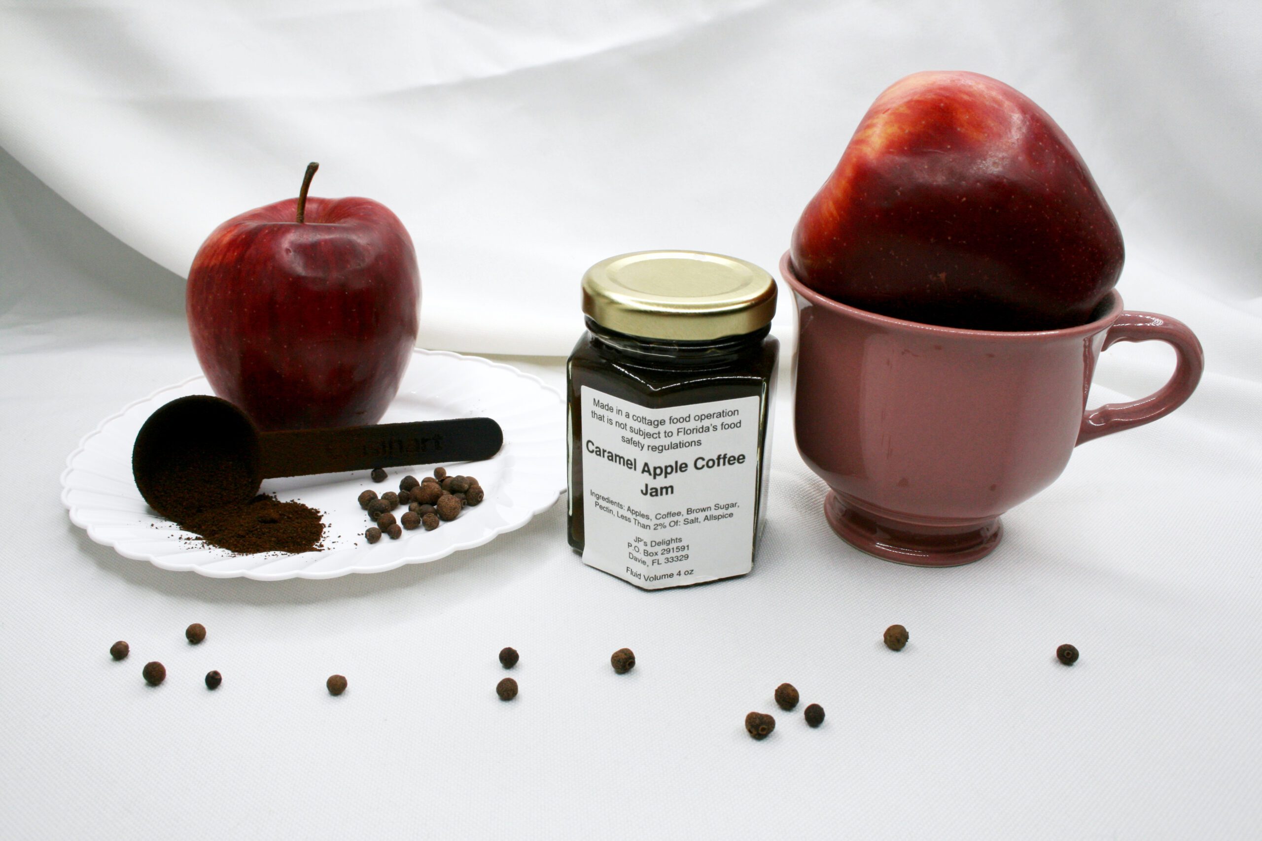 4 oz jar of Caramel Apple Coffee Jam surrounded by its ingredients