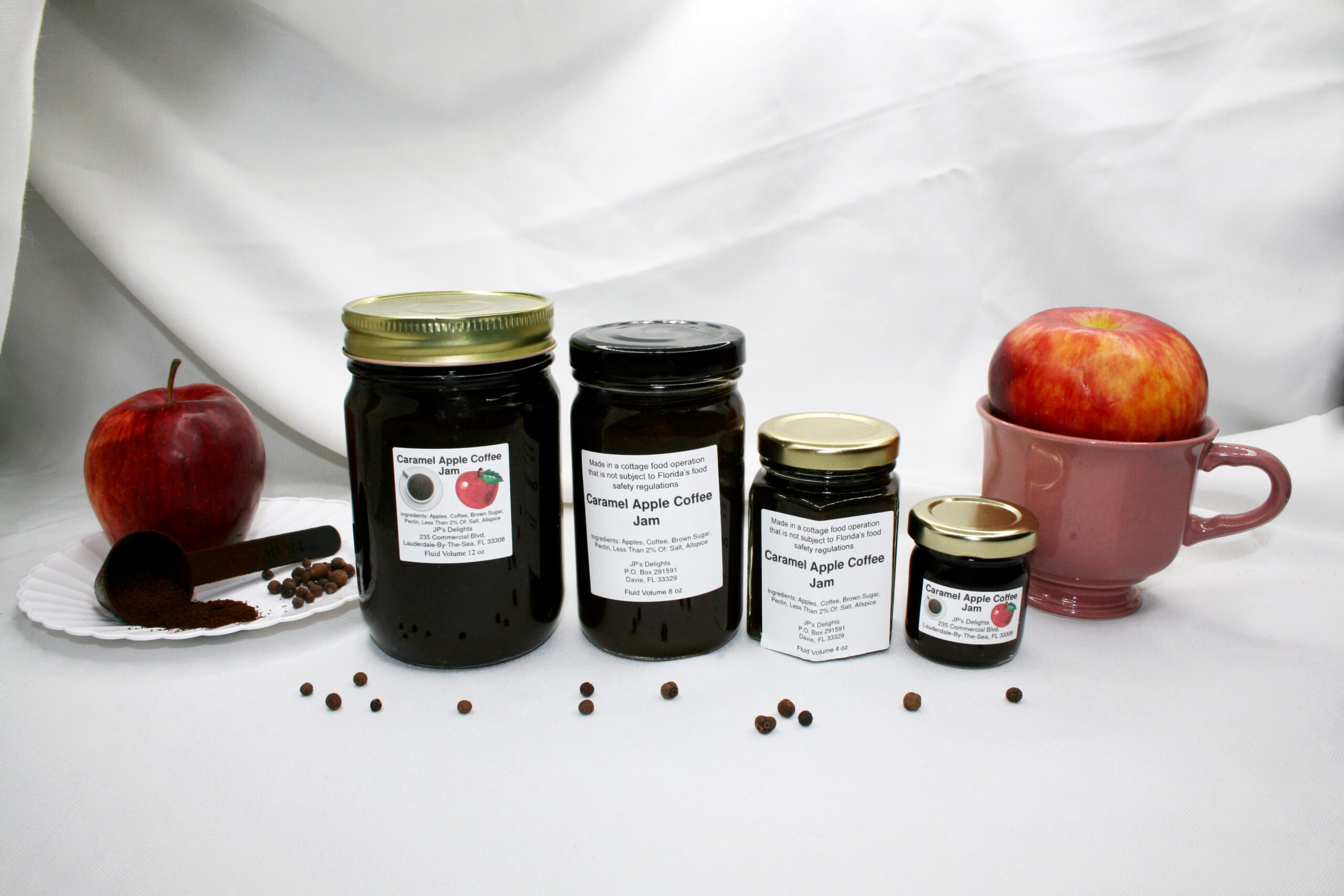 All size jars of Caramel Apple Coffee Jam surrounded by its ingredients