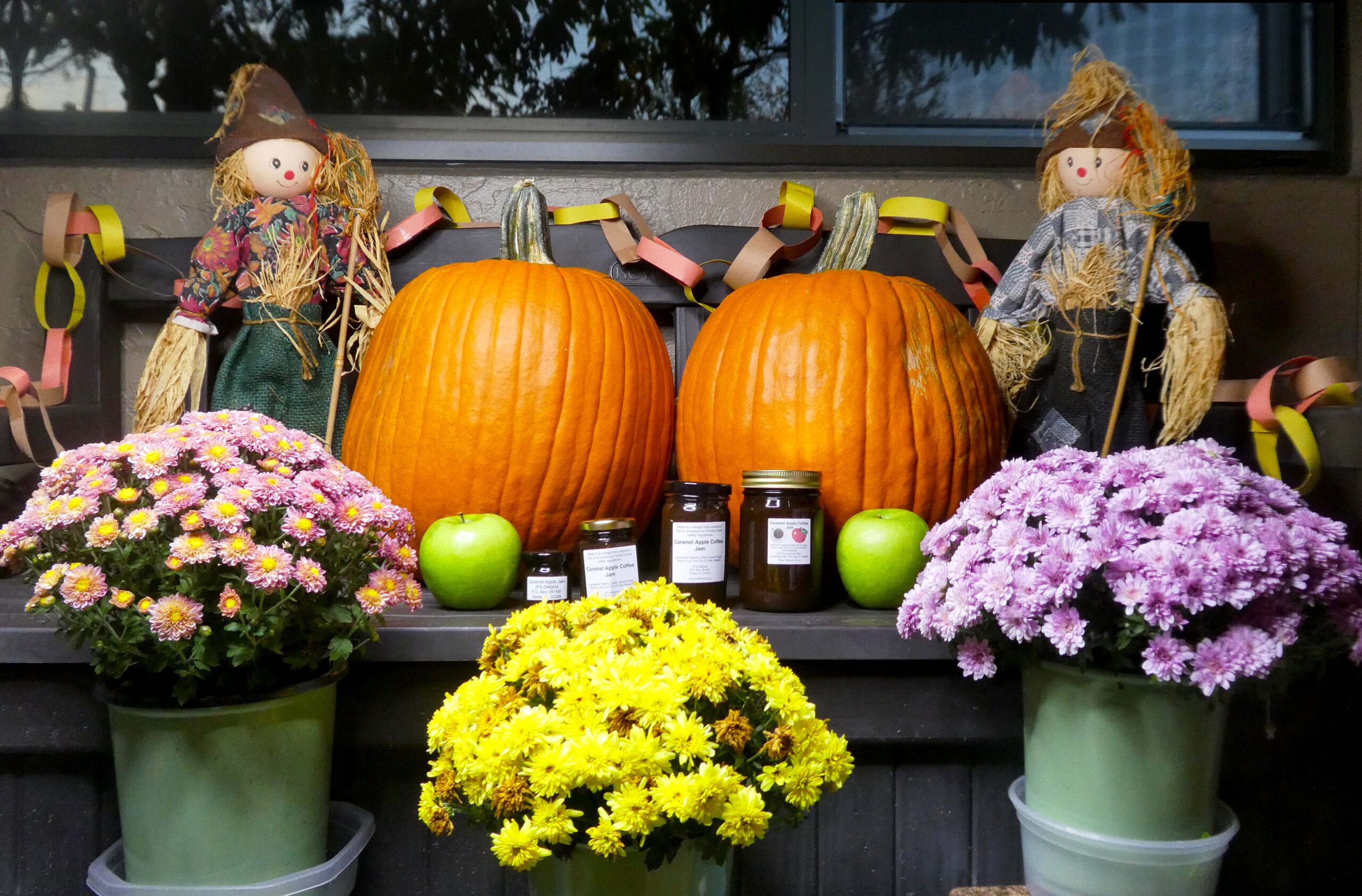 All size jars of Caramel Apple Coffee Jam set in a fall background far shot