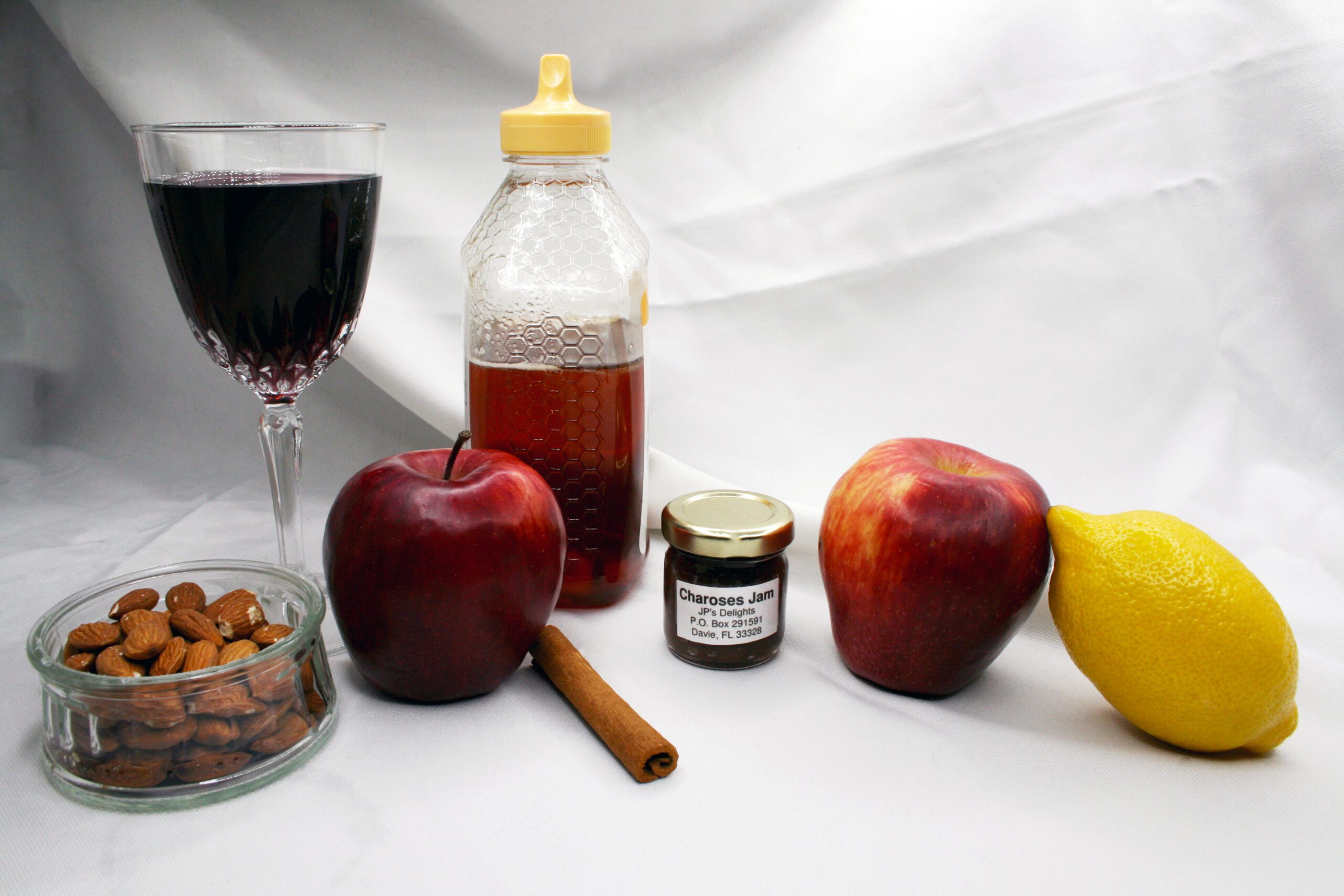 1.5 oz jar of Charoses Jam surrounded by its ingredients